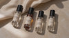 Four Alanoir 2 ml sample perfumes: Imperial Violet, Twilight Oud, Serene Elegance and Bakht, on warm stone.